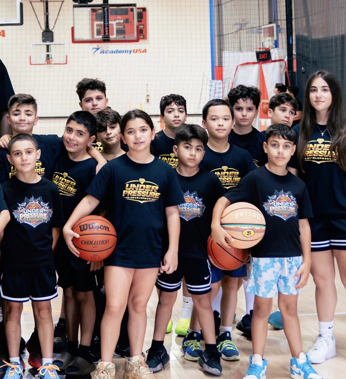 Coach Alique with a group of youth basketball camp players